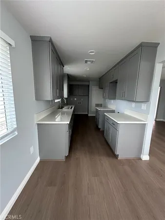 a room with stainless steel appliances wooden floors and wooden floors