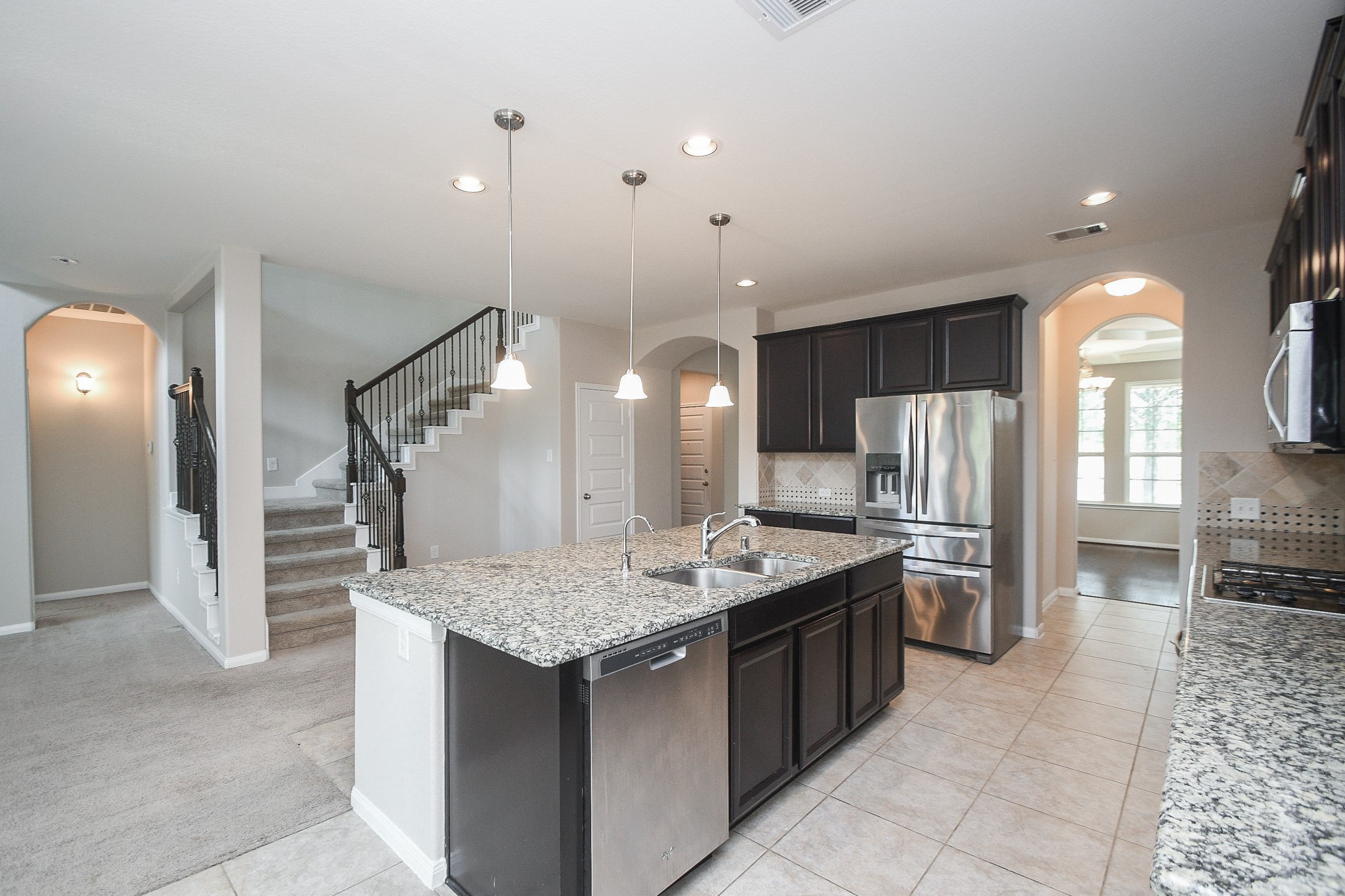22139 Rustling Springs Drive Spring, TX 77389 - Photo 23 of 23 a kitchen with stainless steel appliances kitchen island granite countertop a table and chairs