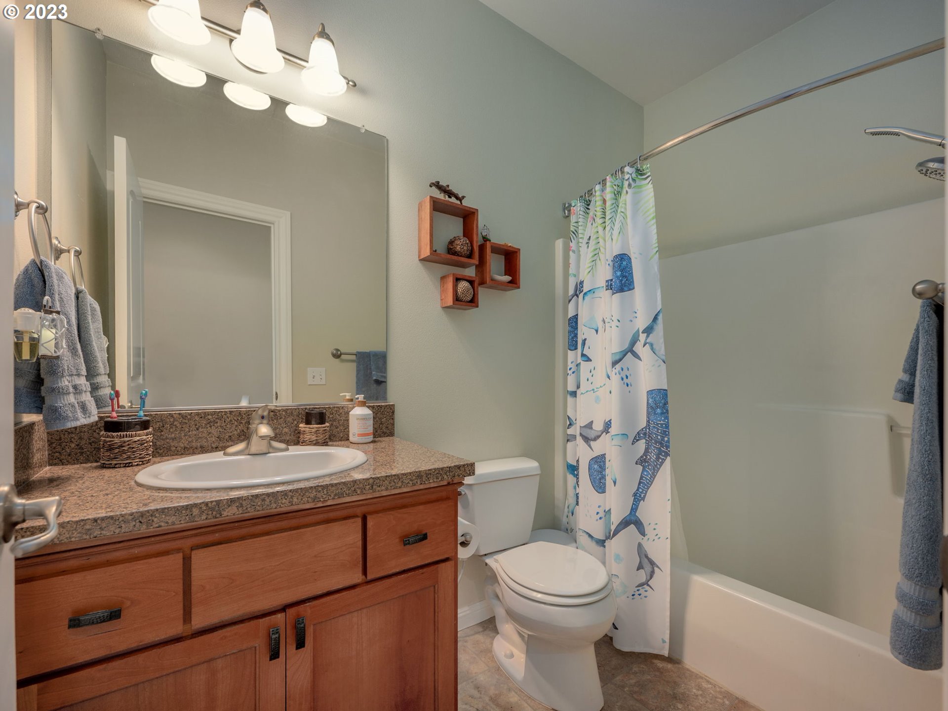 56470 Hazen Road Warren, OR 97053 - Photo 25 of 39 a bathroom with a sink a toilet a large mirror and shower curtain