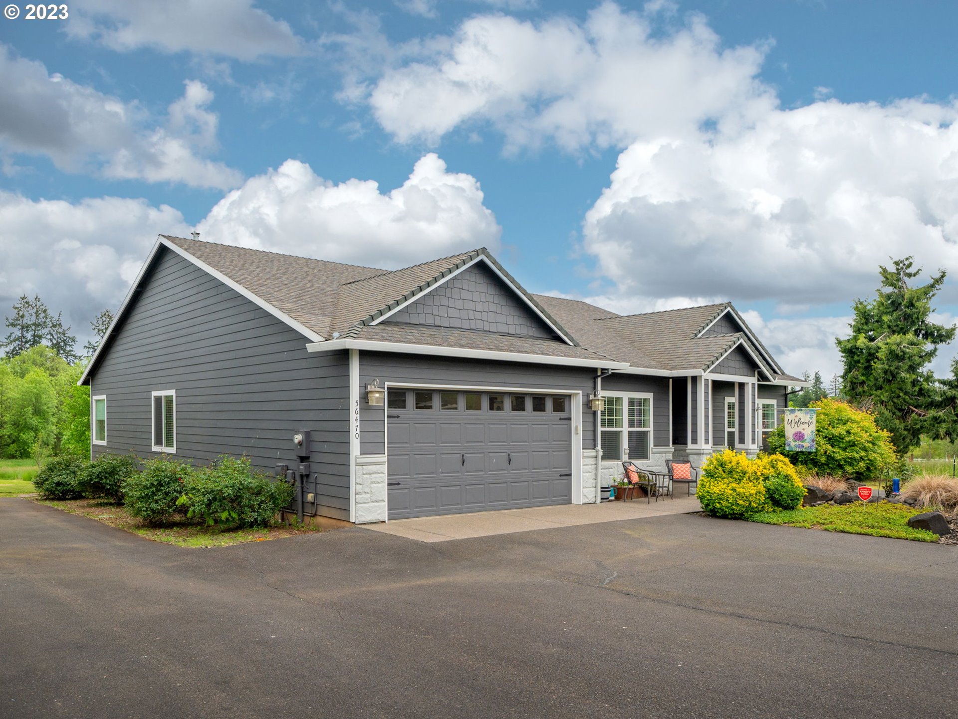 56470 Hazen Road Warren, OR 97053 - Photo 3 of 39 a front view of a house with a yard and garage