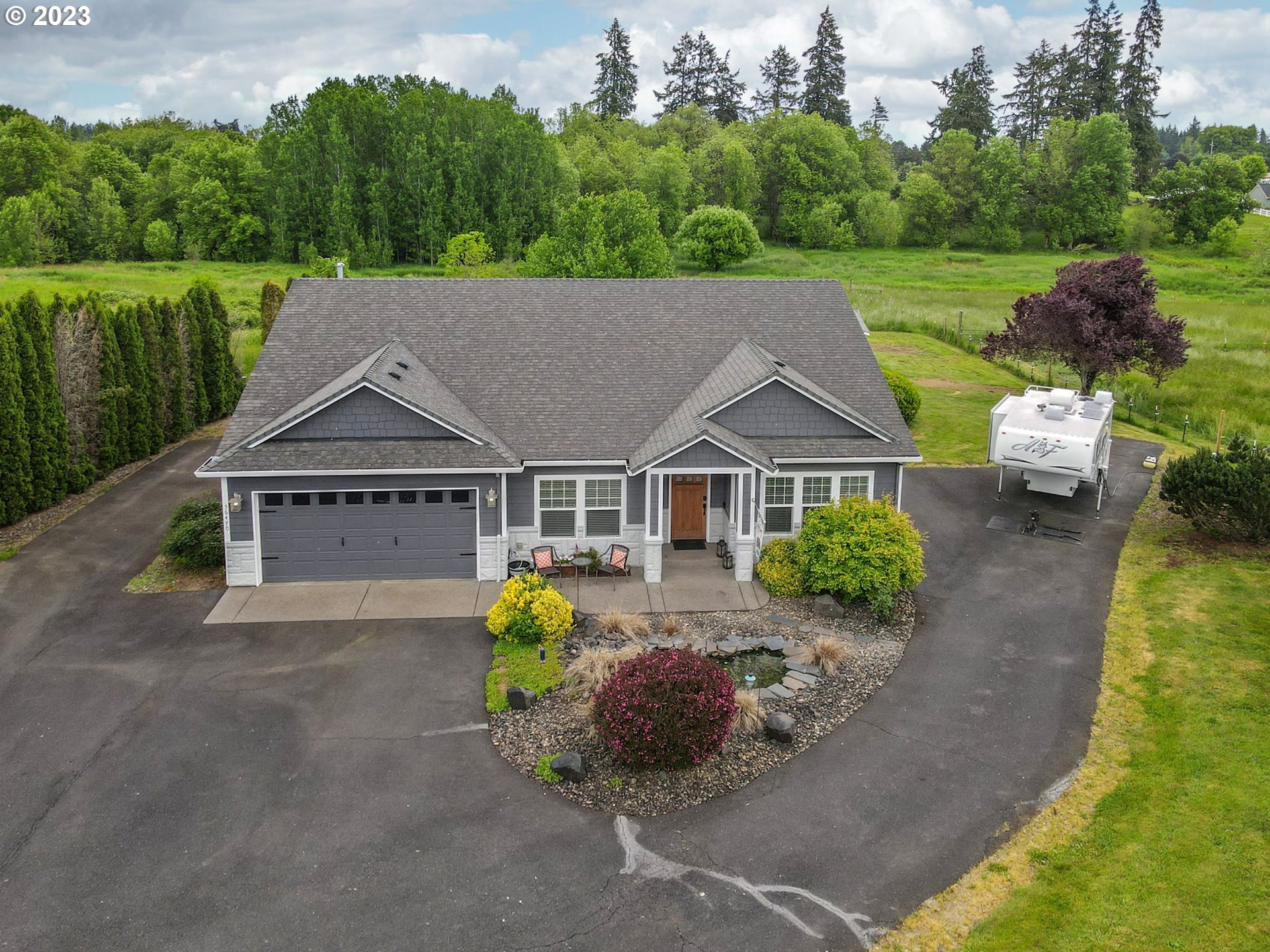 56470 Hazen Road Warren, OR 97053 - Photo 33 of 39 a view of a big house with a big yard and a large tree