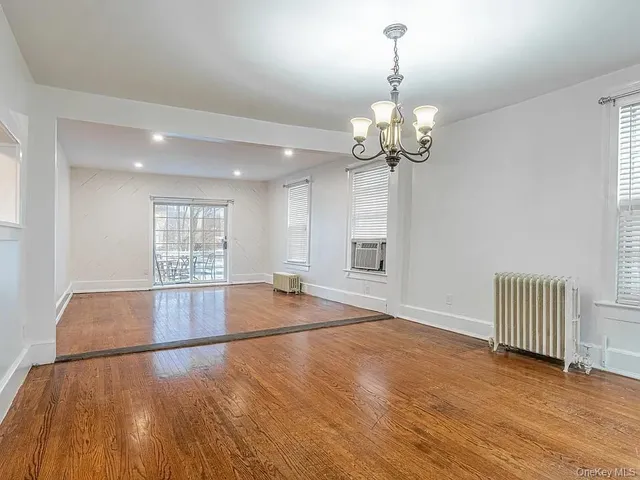 a view of a room with wooden floor and chandelier
