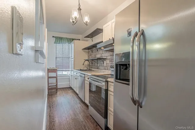 a kitchen with stainless steel appliances a refrigerator and a hard wood floor