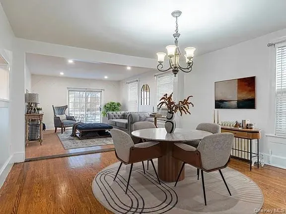 a view of a dining room with furniture a chandelier and wooden floor
