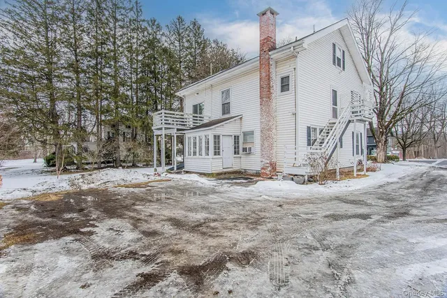 a view of a white house with a snow on the road
