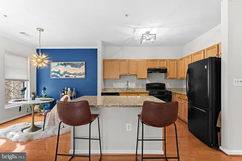 a kitchen with stainless steel appliances granite countertop a refrigerator and a stove top oven