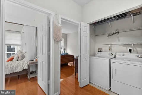 a view of walk in closet with wooden floor and bedroom view
