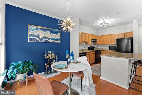 a view of a dining room with furniture a rug and wooden floor