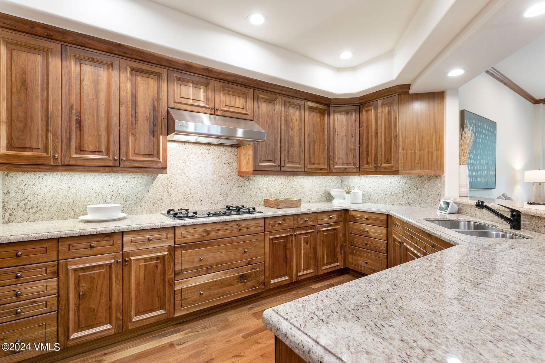 15 West Thomas Place, Unit R44 Beaver Creek, CO 81620 - Photo 5 of 21 a kitchen with granite countertop wooden cabinets stainless steel appliances a sink and a window