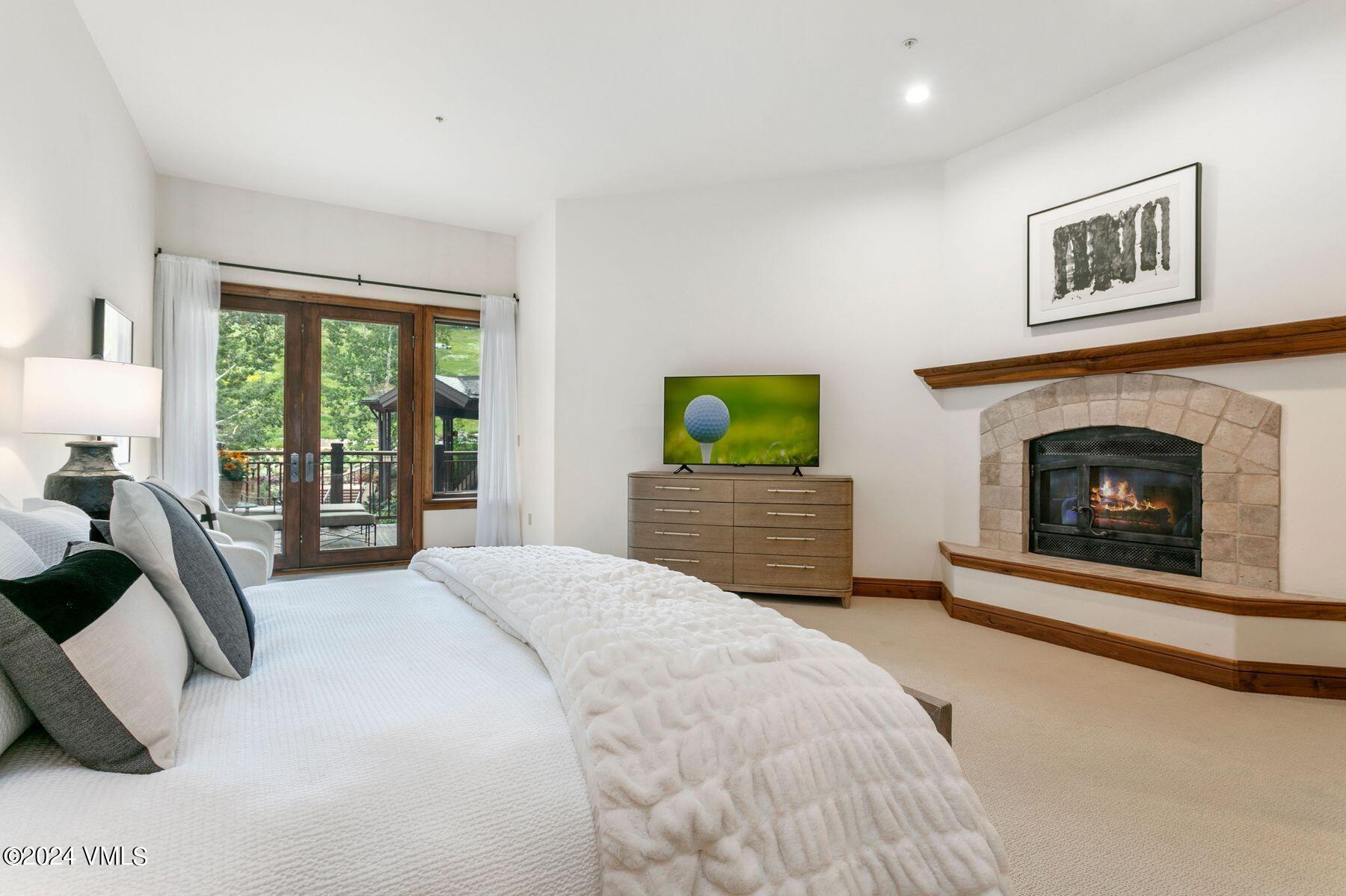 15 West Thomas Place, Unit R44 Beaver Creek, CO 81620 - Photo 8 of 21 a spacious bedroom with a balcony a bed and a fireplace