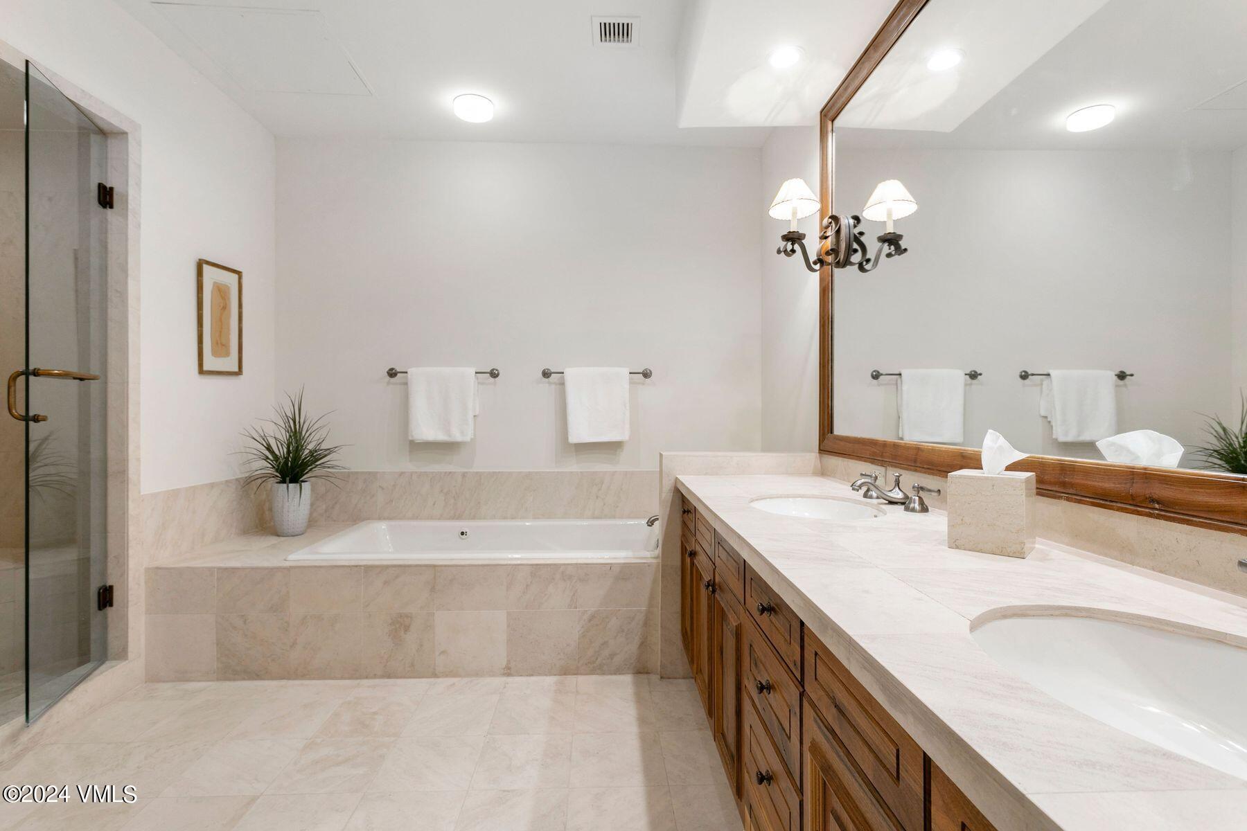 15 West Thomas Place, Unit R44 Beaver Creek, CO 81620 - Photo 10 of 21 a spacious bathroom with a double vanity sink a mirror and a bathtub
