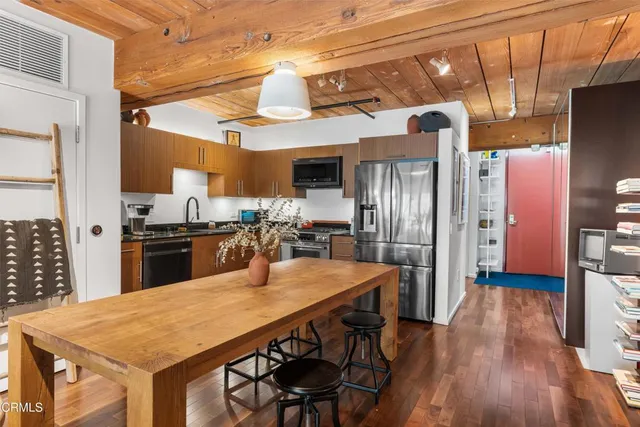 a kitchen with stainless steel appliances granite countertop a refrigerator a stove top oven a sink dishwasher and wooden cabinets