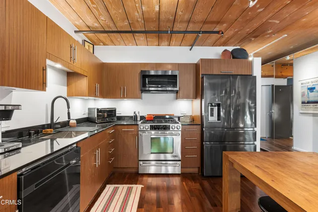 a kitchen with kitchen island granite countertop a stove and a refrigerator