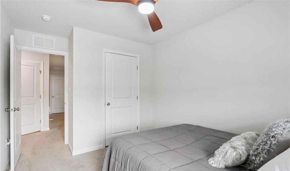 1138 Martin Road Breinigsville, PA 18031 - Photo 7 of 9 A well-lit bedroom features plush carpeting and a modern ceiling fan.