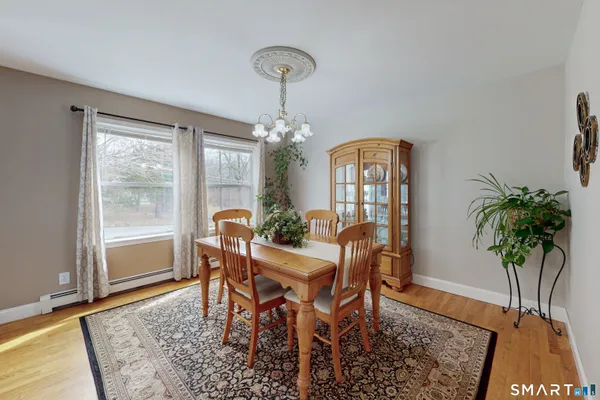 a dining room with chandelier and wooden floor