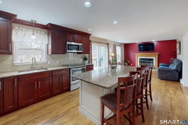 a kitchen with stainless steel appliances granite countertop a sink table and chairs
