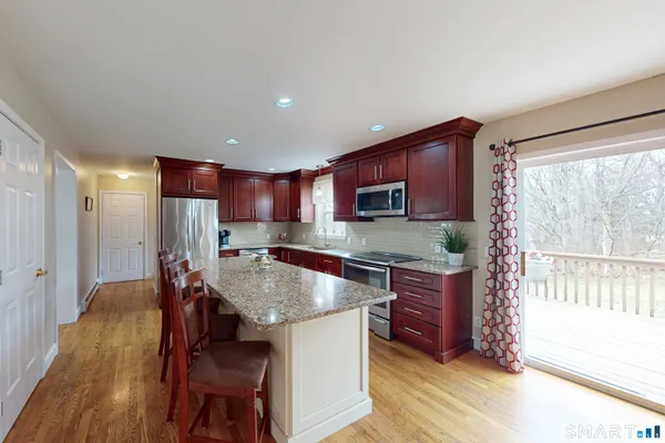a kitchen with stainless steel appliances granite countertop a stove top oven a sink and a refrigerator