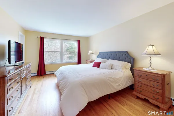 a bedroom with a bed and wooden floor