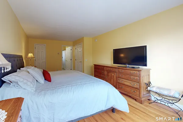 a bedroom with a large bed and a flat screen tv
