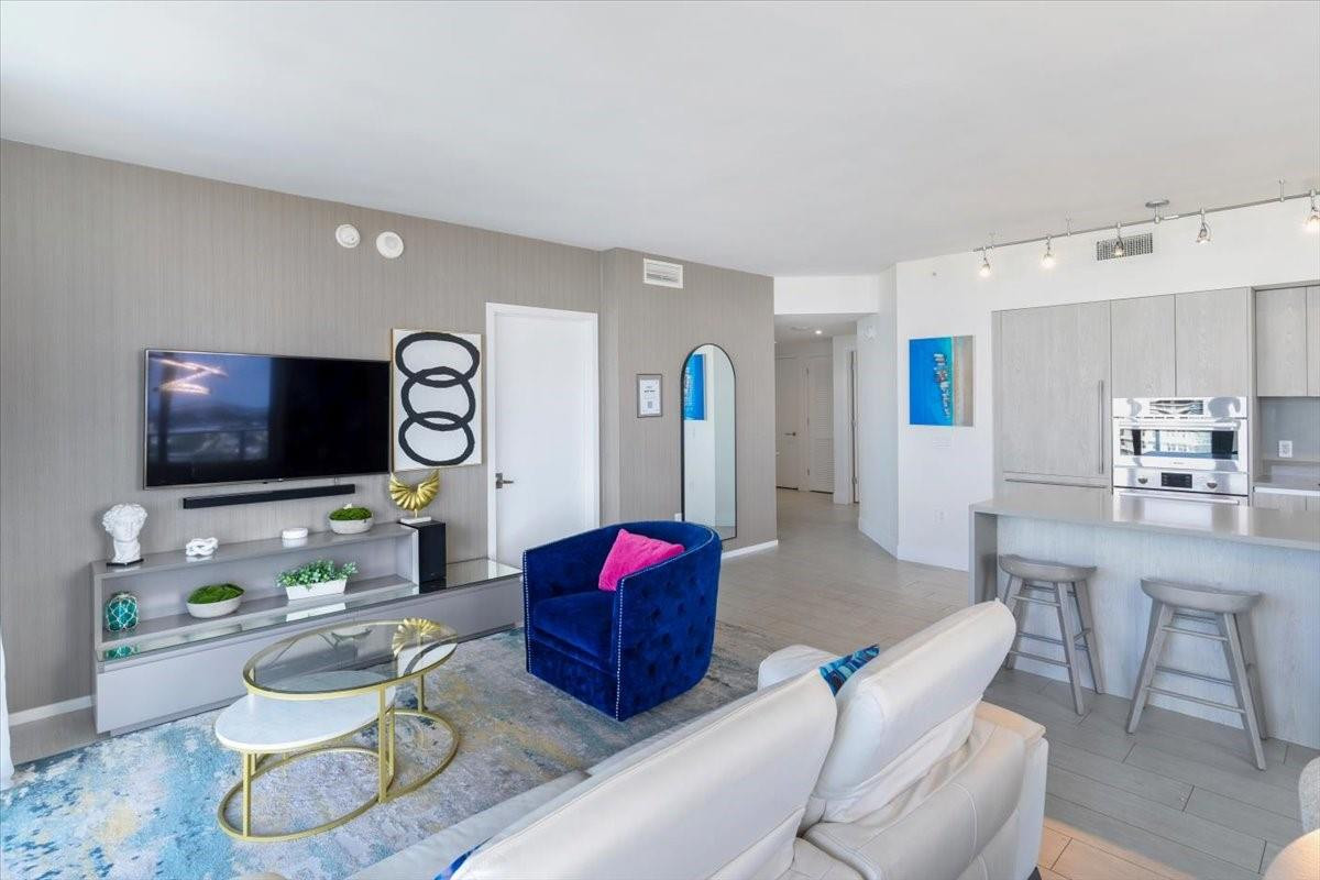 4010 South Ocean Drive, Unit R1102 Hollywood, FL 33019 - Photo 16 of 47 a living room with furniture and a flat screen tv