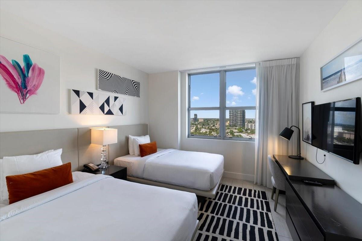 4010 South Ocean Drive, Unit R1102 Hollywood, FL 33019 - Photo 30 of 47 a bedroom with two beds and a flat screen tv