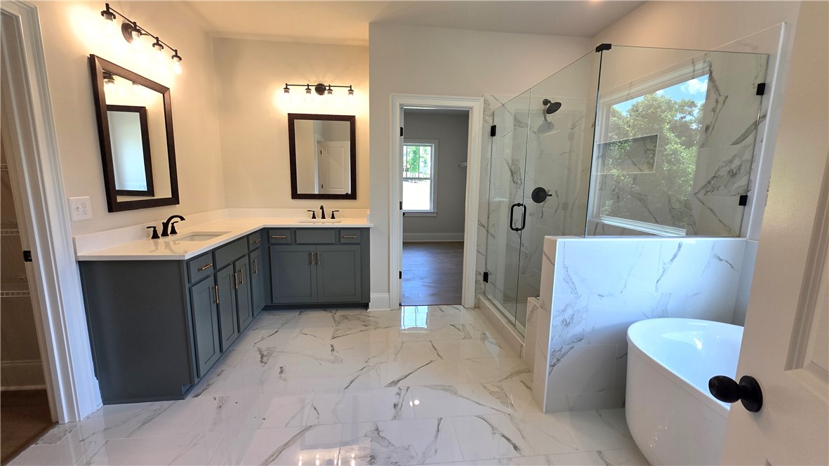 243 Holly Br Road Piedmont, SC 29673 - Photo 15 of 21 Marble-look tile flooring leads to a generous walk-in shower and dual vanities, creating a luxurious private oasis.