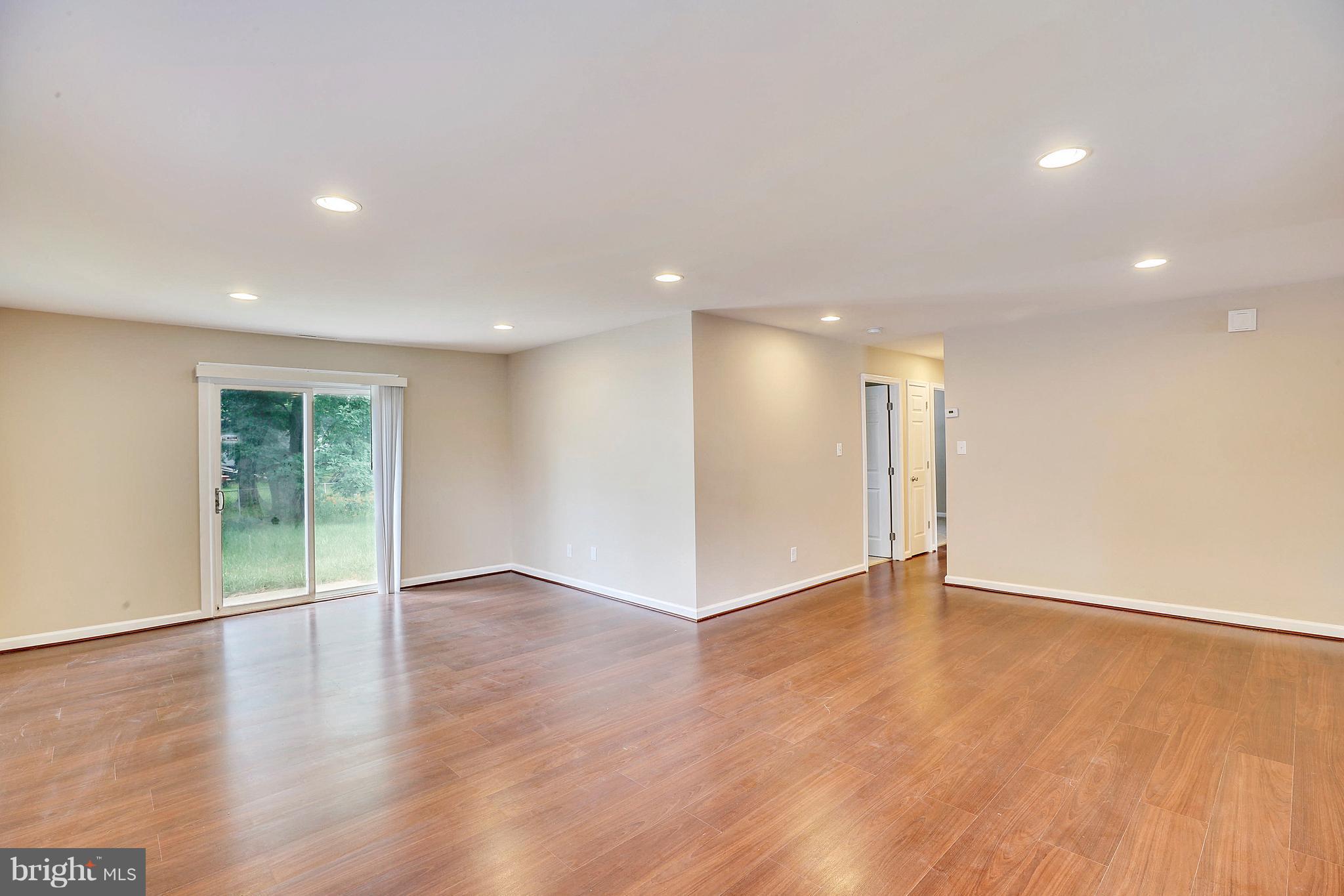 1718 Newcastle Road Baltimore, MD 21244 - Photo 3 of 9 a view of an empty room with wooden floor and a window