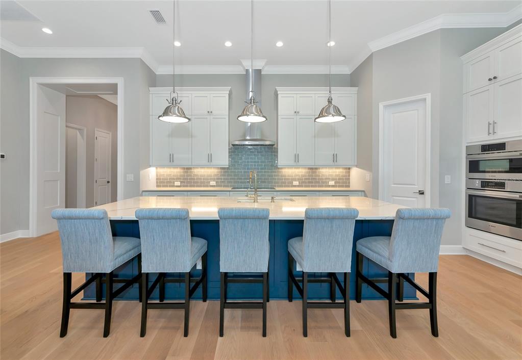 16620 Collingtree Crossing Lakewood Ranch, FL 34202 - Photo 7 of 48 a dining room with kitchen island a table and chairs