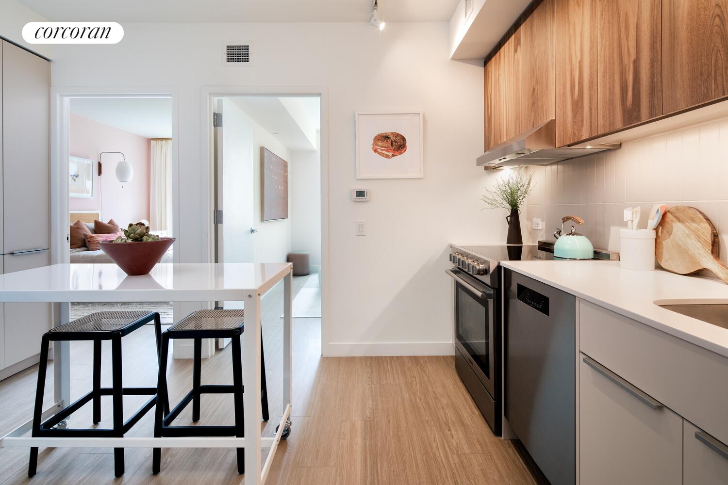 a kitchen with stainless steel appliances a dining table chairs and wooden floor