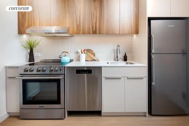 a kitchen with stainless steel appliances a dining table chairs and wooden floor
