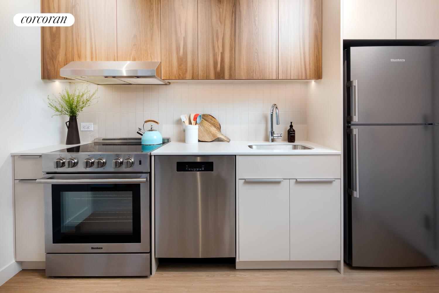 30-77 Vernon Boulevard, Unit 622W Queens, NY 11106 - Photo 2 of 8 a kitchen with stainless steel appliances granite countertop a stove a refrigerator and a sink