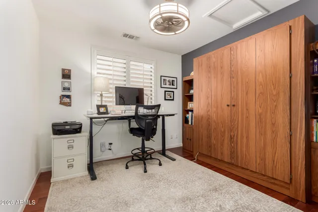 a view of a workspace with furniture and a window