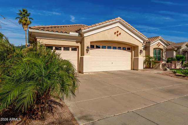 a front view of a house with a yard and potted plants