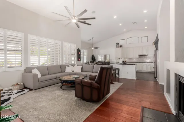 a living room with furniture kitchen area and a large window