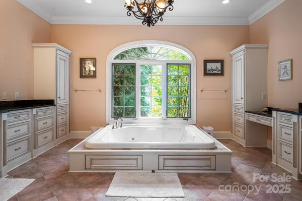 a spacious bathroom with a granite countertop tub and a large window