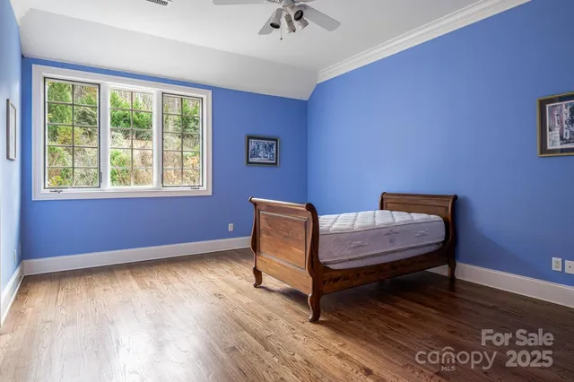a view of a room with wooden floor and a ceiling fan