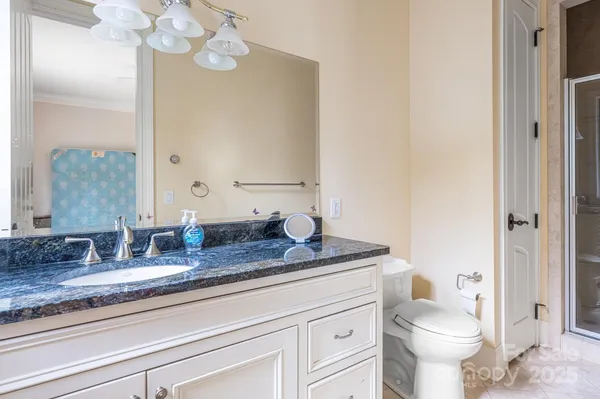 a bathroom with a granite countertop toilet sink and mirror