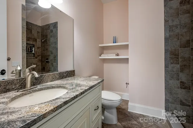 a bathroom with a granite countertop sink toilet and shower