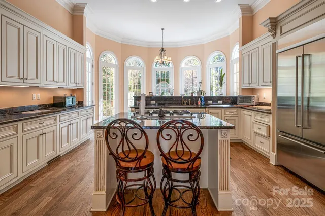 a view of a kitchen with granite countertop a stove a sink and cabinets