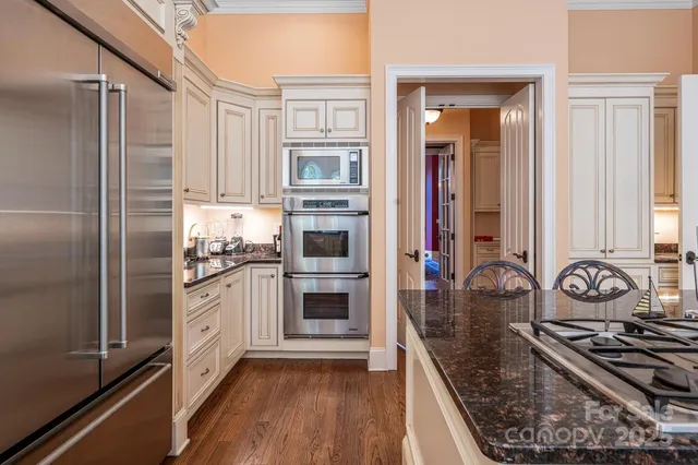 a kitchen with stainless steel appliances granite countertop a stove refrigerator and cabinets