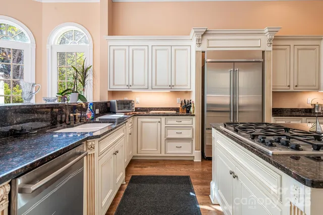 a kitchen with stainless steel appliances granite countertop a stove a sink and a refrigerator