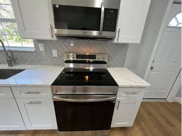 a stove top oven sitting inside of a kitchen