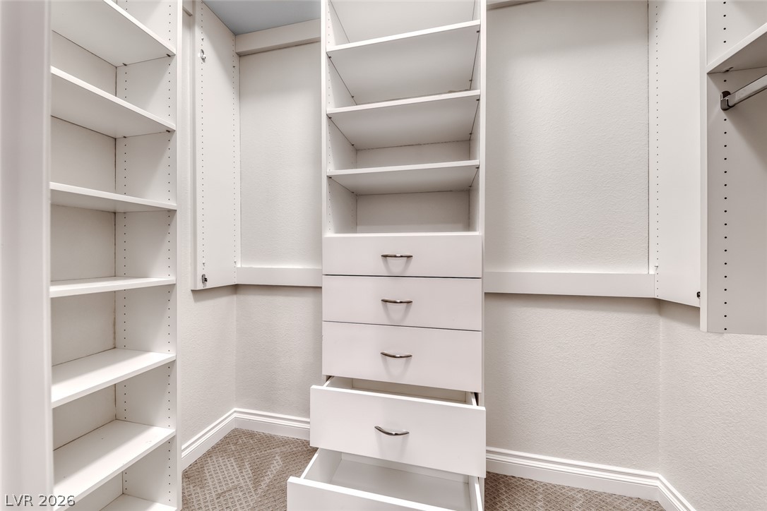 2122 Mooreview Street Henderson, NV 89012 - Photo 28 of 44 Custom shelving and drawers offer organized storage solutions within this well-appointed walk-in closet.