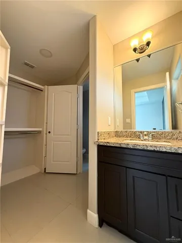 a bathroom with a granite countertop sink a mirror and a bathtub