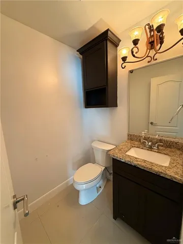 a bathroom with a granite countertop toilet and a sink