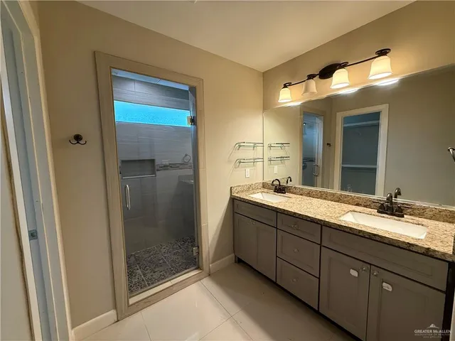 a bathroom with a granite countertop sink mirror and shower