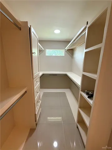 a view of walk in closet with empty racks