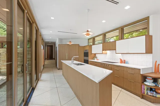 a kitchen with a sink a refrigerator and cabinets