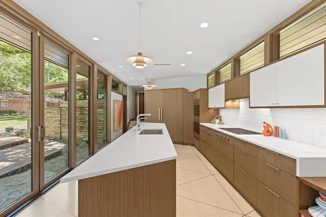 a large white kitchen with a large window