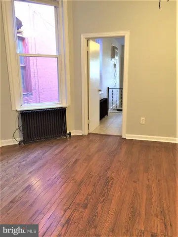 a view of a room with wooden floor and windows